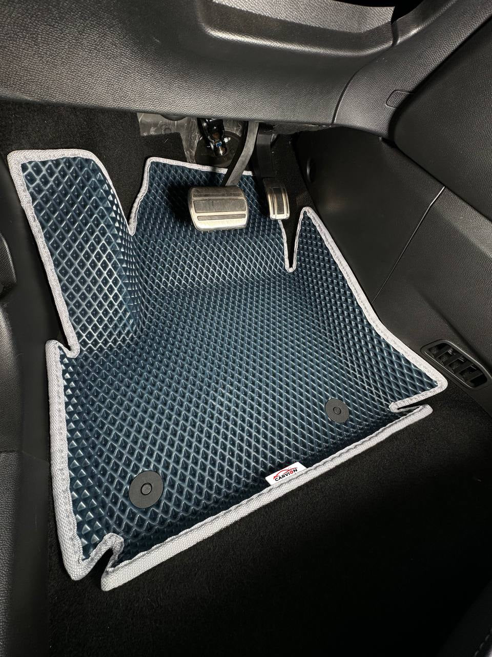 Photo d’illustration : tapis EVA 3D bleu marine avec rebords surélevés et bordure grise, côté conducteur